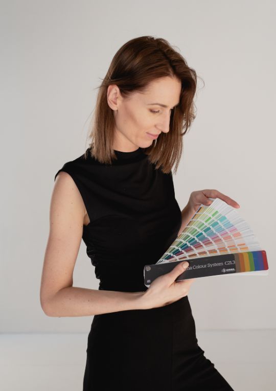 Projektantka wnętrz Good Home Studio przeglądająca katalogi i materiały wykończeniowe podczas pracy nad projektem wnętrza